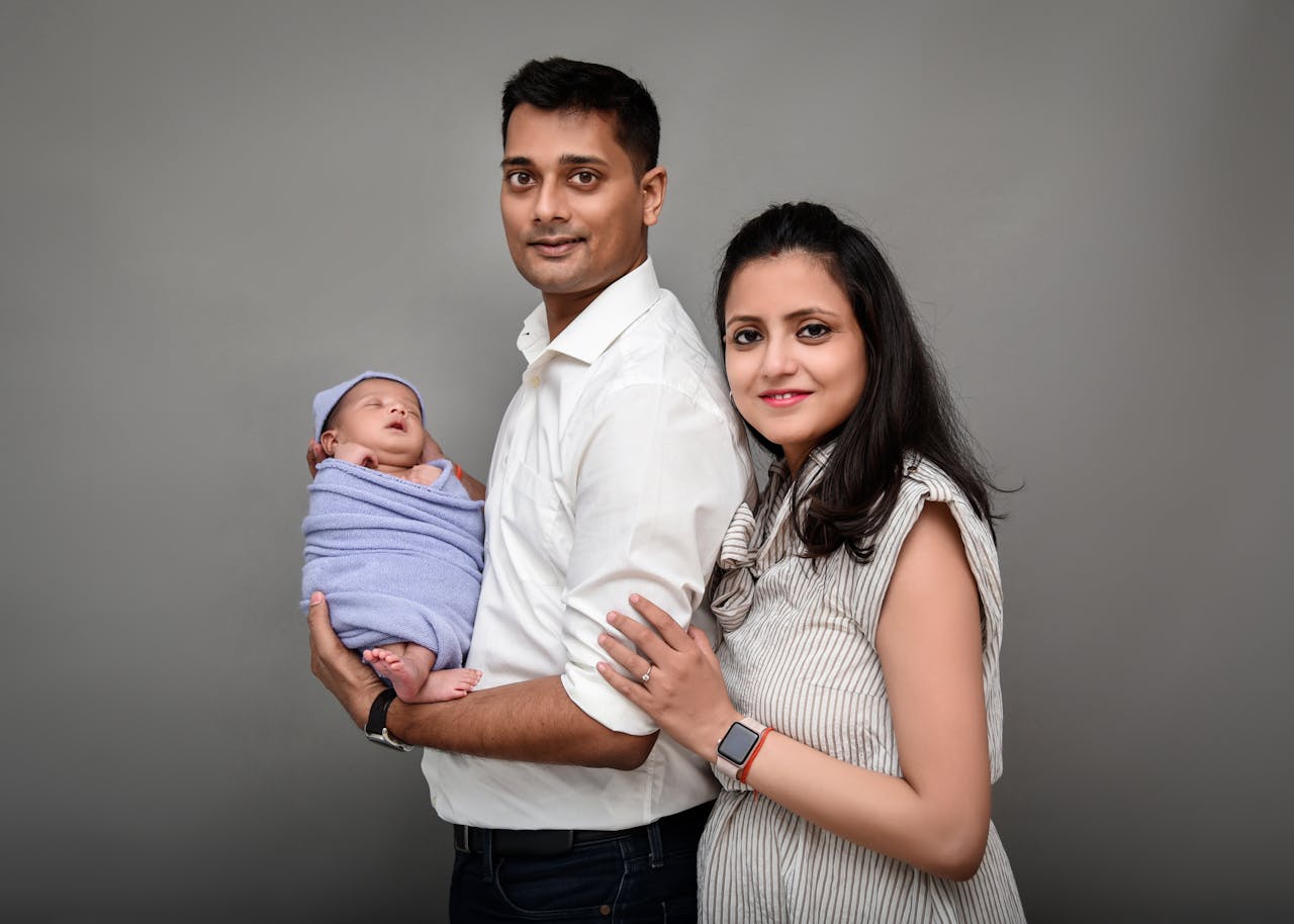A loving family with their newborn baby posed in a professional studio. Captured happiness and connection.